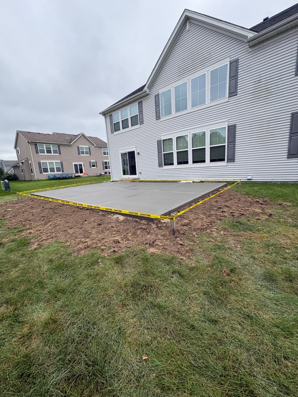 Freshly finished concrete patio behind a house