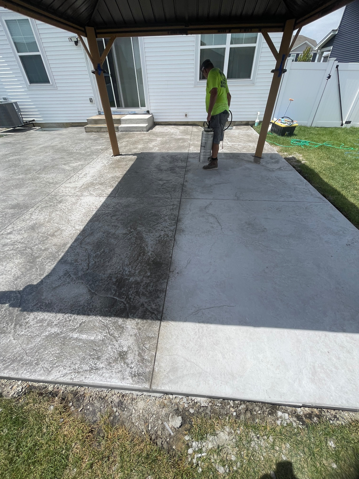 Stamped concrete patio sealer application close-up